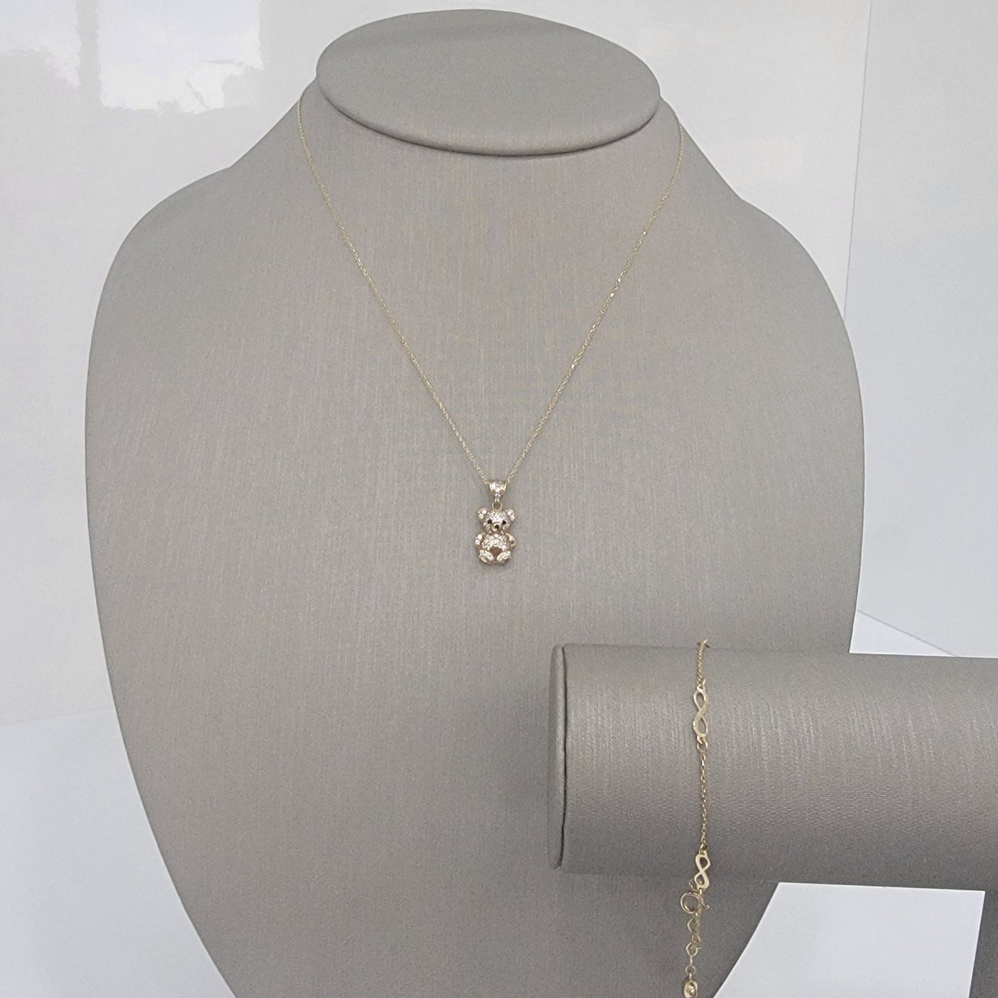 Set. Cadena con dije de oso y pulsa con infinito.Oro 10k.